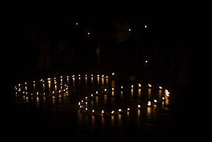 Velas acesas formando o número 60, em um fundo negro