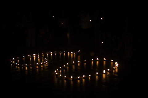 Velas acesas formando o número 60, em um fundo negro