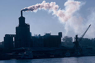 Densa fumaça saindo de uma indústria poluente ao longo do rio Armur na cidade de Heihe, China.